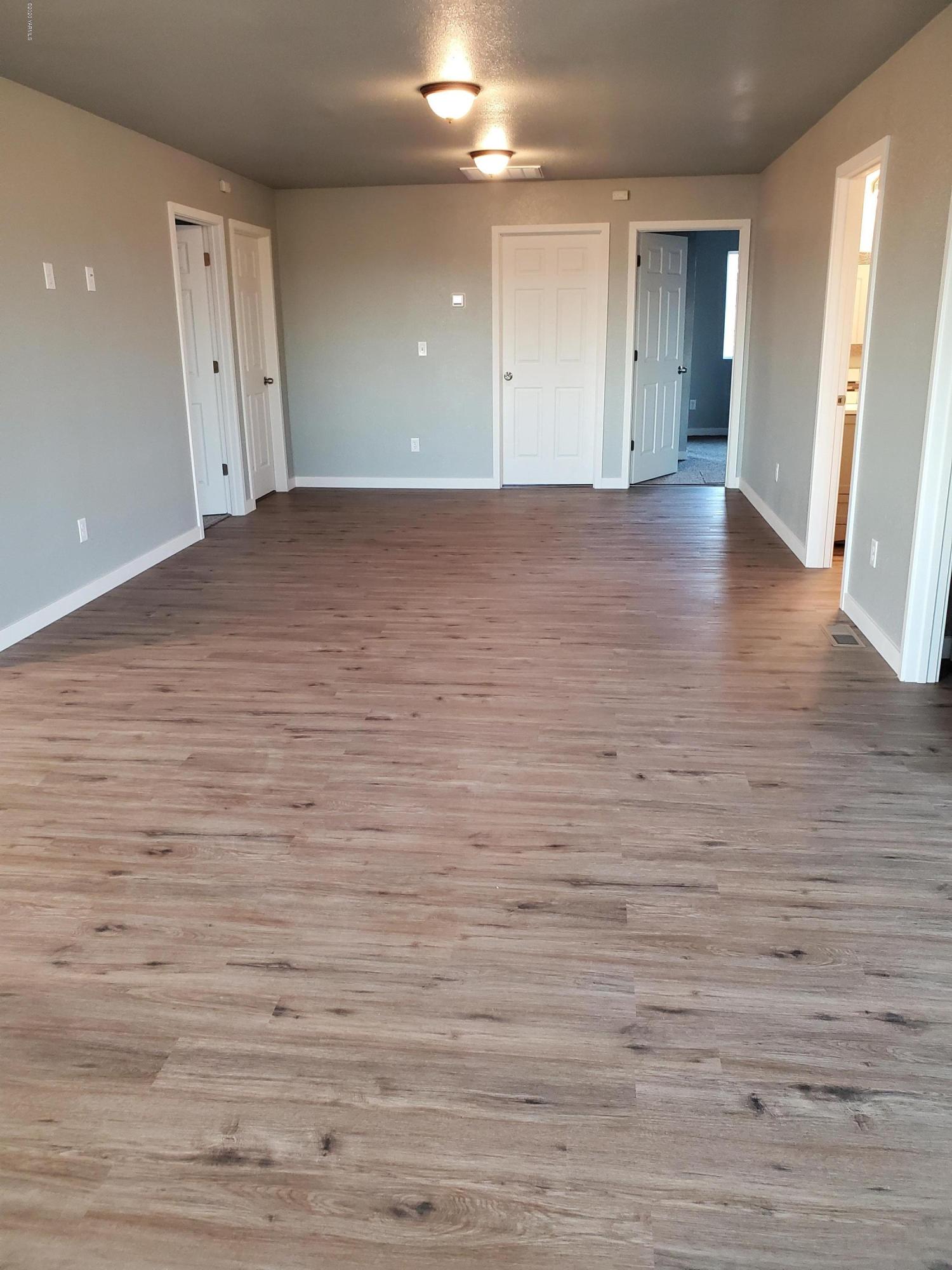 609 Bagley Road Granger, WA 98932 - Photo 2 of 11 an empty room with wooden floor and windows