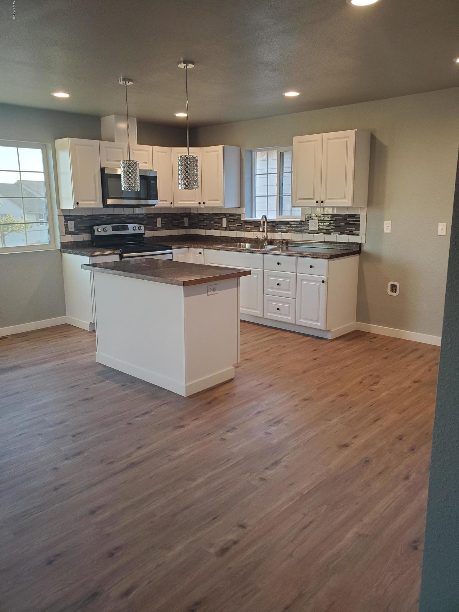 609 Bagley Road Granger, WA 98932 - Photo 3 of 11 a kitchen with stainless steel appliances granite countertop a stove a sink and a microwave