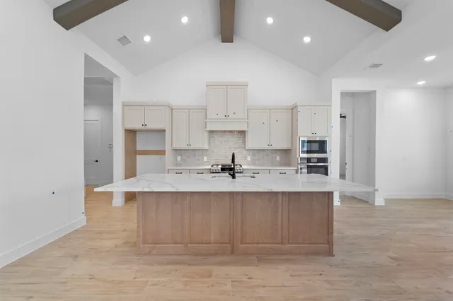 a large kitchen with kitchen island a sink stainless steel appliances and cabinets
