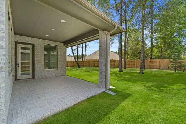 a view of a house with backyard and a large tree