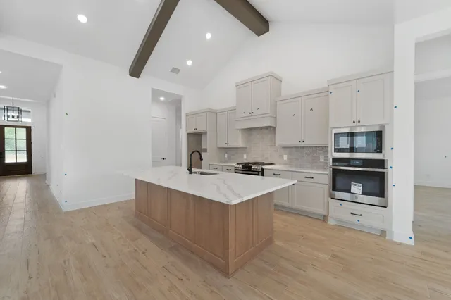 a kitchen with stainless steel appliances a sink stove and cabinets