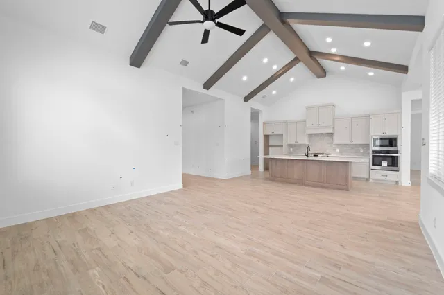 a view of a kitchen with kitchen island a sink stainless steel appliances and cabinets