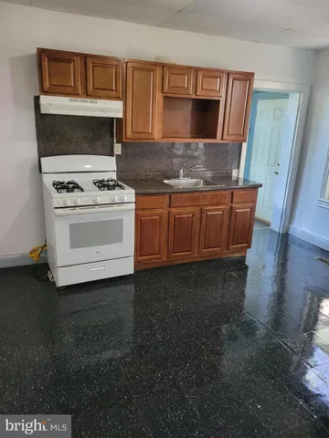 a kitchen with granite countertop a stove and a microwave oven