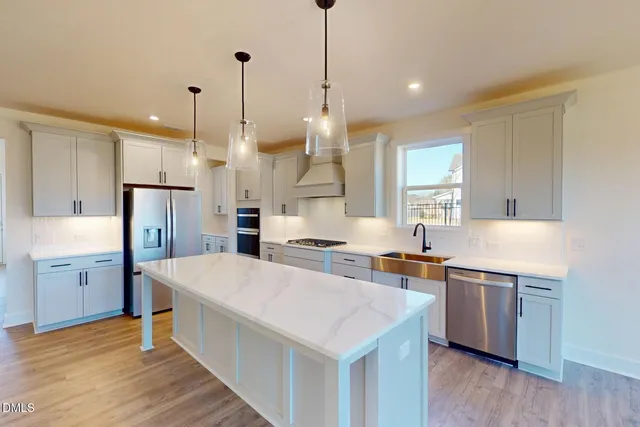 a large kitchen with kitchen island a sink stainless steel appliances and white cabinets