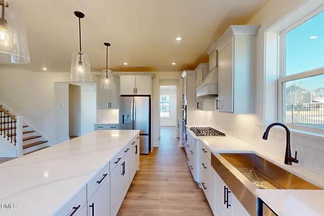 a large kitchen with white cabinets and stainless steel appliances