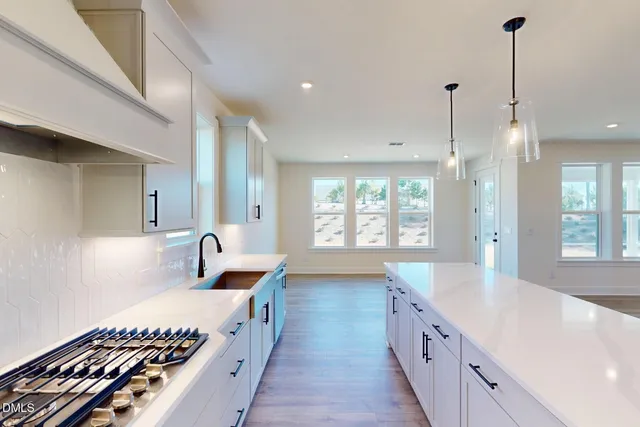 a open kitchen with stainless steel appliances granite countertop a sink a stove and a refrigerator