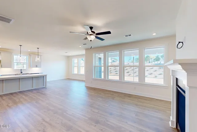 a view of an empty room with a window and a fireplace