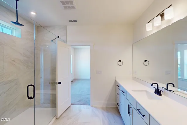 a bathroom with a double vanity sink and glass door
