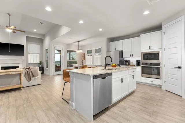 a large kitchen with stainless steel appliances and a stove top oven