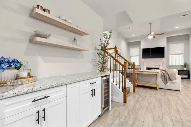 a open kitchen with stainless steel appliances granite countertop a lot of white cabinets and wooden floor