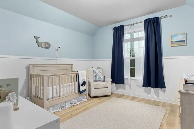 a bedroom with furniture and a large window