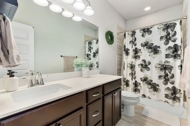 a bathroom with a sink a toilet and shower curtain