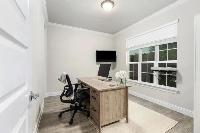 a view of a workspace with furniture and a window