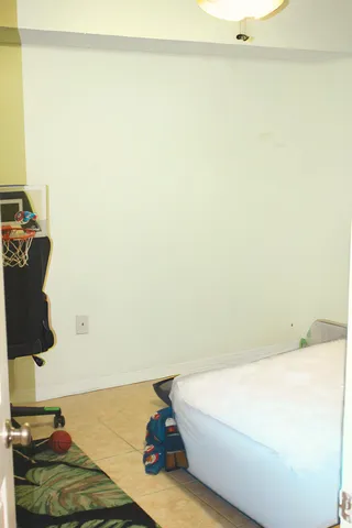 a bed sitting in a bedroom next to a window