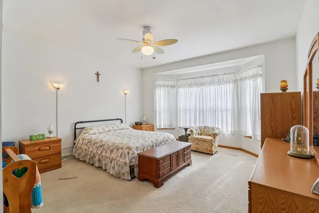 a bedroom with a large bed and a chandelier