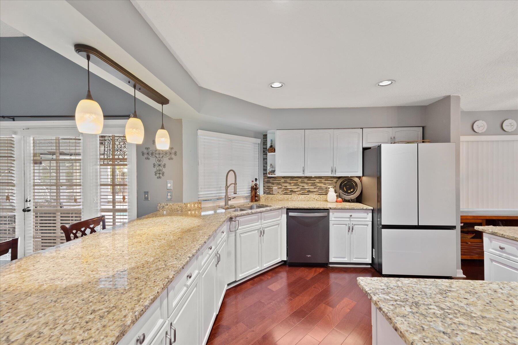 1373 Brampton Cove Wellington, FL 33414 - Photo 10 of 35 a kitchen with a sink a refrigerator and wooden cabinets