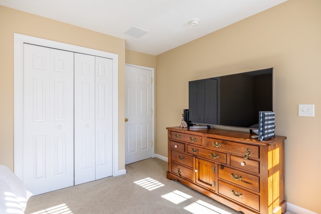 90 Central Street, Unit 2 East Bridgewater, MA 02333 - Photo 16 of 26 a living room with furniture flat screen tv and cabinets