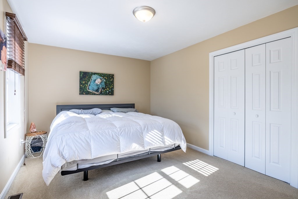 90 Central Street, Unit 2 East Bridgewater, MA 02333 - Photo 17 of 26 a bed sitting in a bedroom next to a lamp