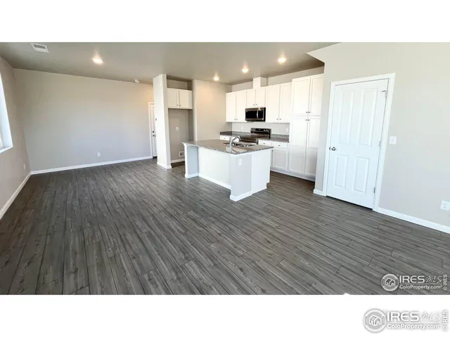 a kitchen with cabinets and wooden floor