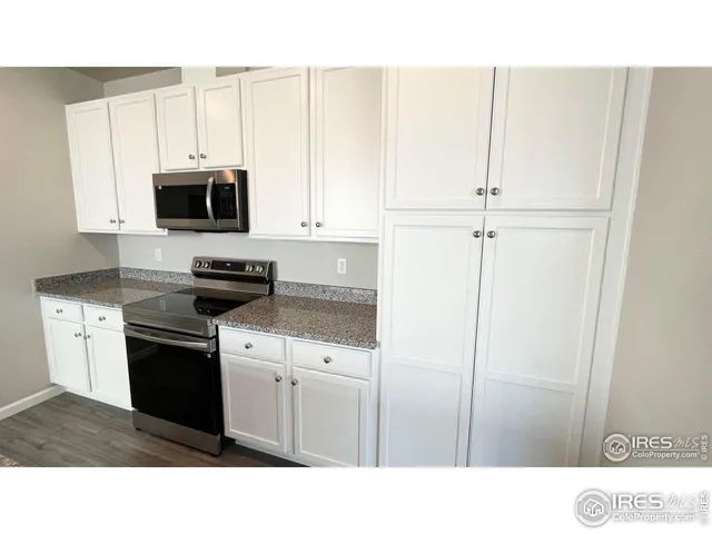 a kitchen with white cabinets and stainless steel appliances