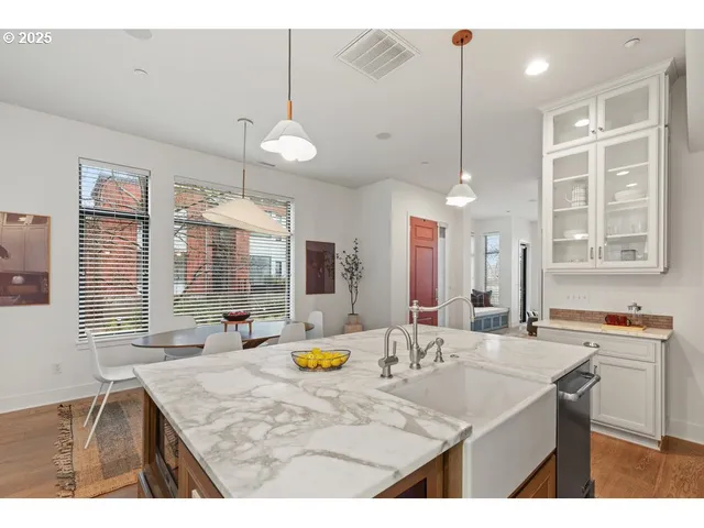 a kitchen with a sink a counter space appliances and cabinets