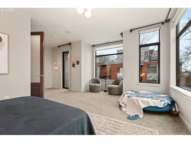a bedroom with furniture and a large window