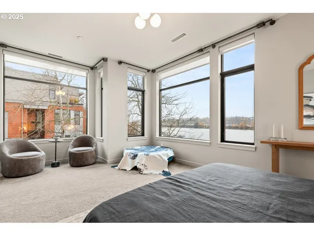 a bedroom with furniture and large windows