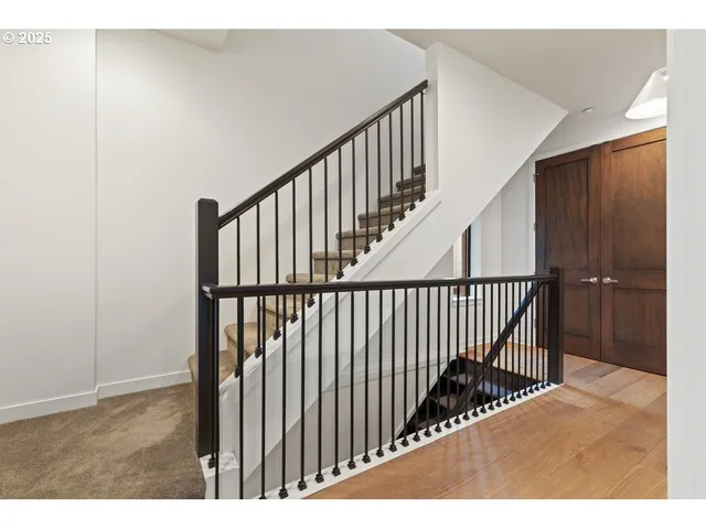 a view of staircase with railing and white walls