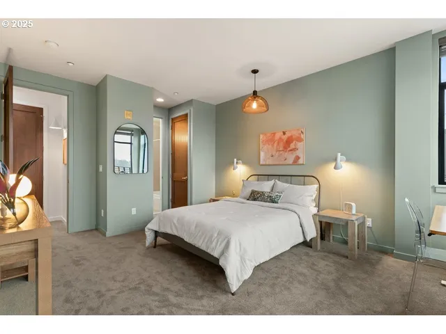 a bedroom with a bed and a flat tv screen on dresser