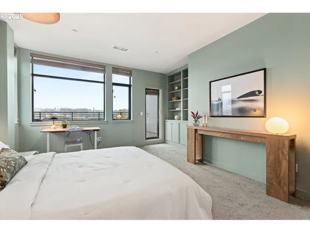 a bedroom with a large bed and a flat tv screen on dresser