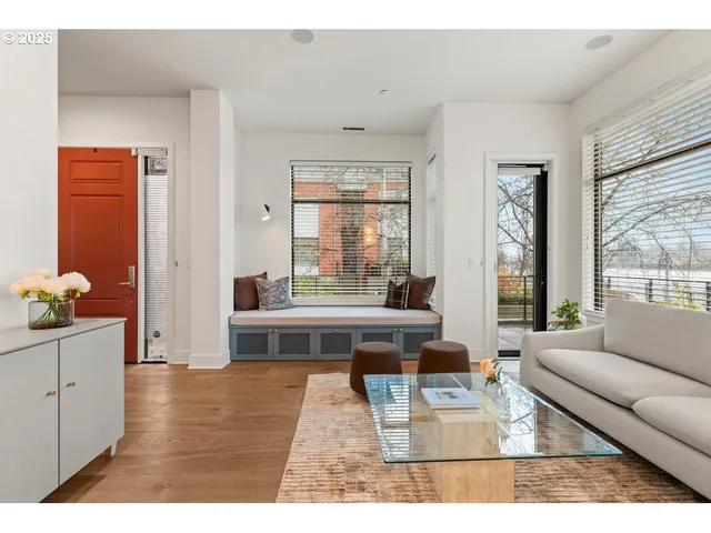 a living room with furniture a wooden floor and windows