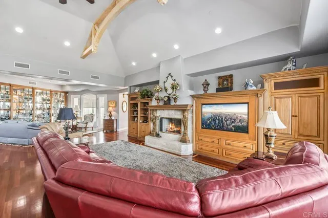 a living room with furniture a fireplace and a chandelier