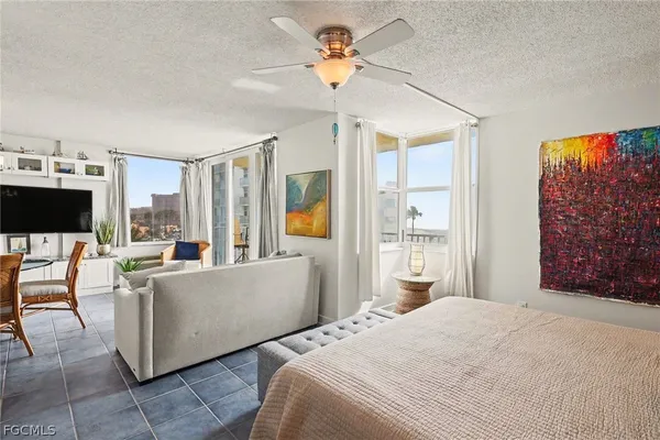 a living room with furniture a flat screen tv and a large window