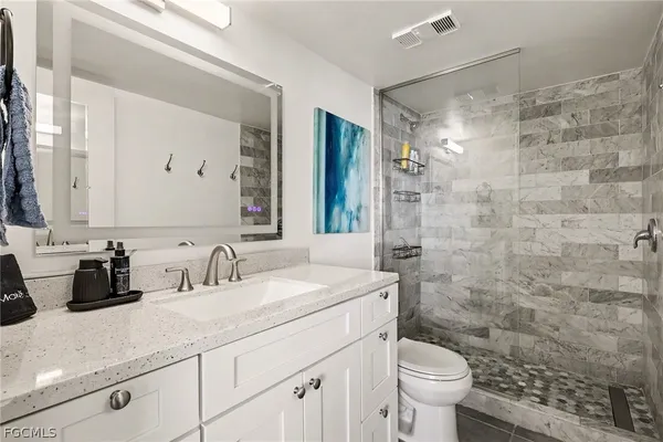 a bathroom with a sink a toilet and shower