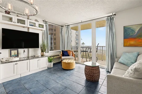 a living room with furniture a flat screen tv and a large window