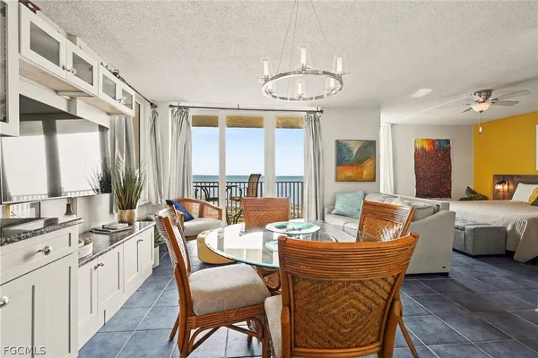 a dining room with wooden floor a chandelier a wooden table and chairs