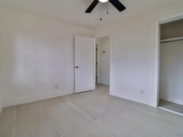 an empty room with chandelier fan