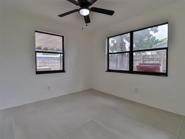 an empty room with windows and fan