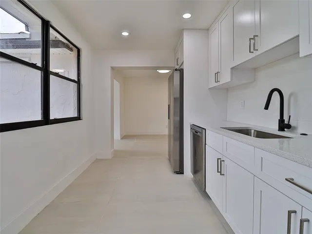a kitchen with stainless steel appliances a refrigerator sink and cabinets