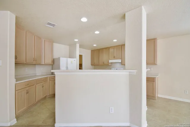 a view of a kitchen with kitchen island and stainless steel appliances