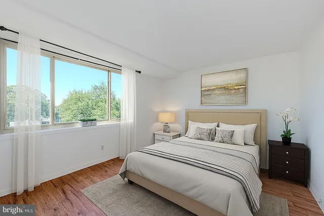 a bedroom with a bed and a large window