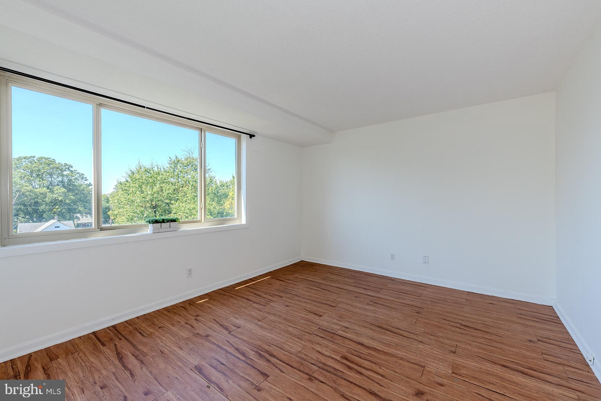 4410 Oglethorpe Street, Unit 713 Hyattsville, MD 20781 - Photo 15 of 24 an empty room with wooden floor and windows
