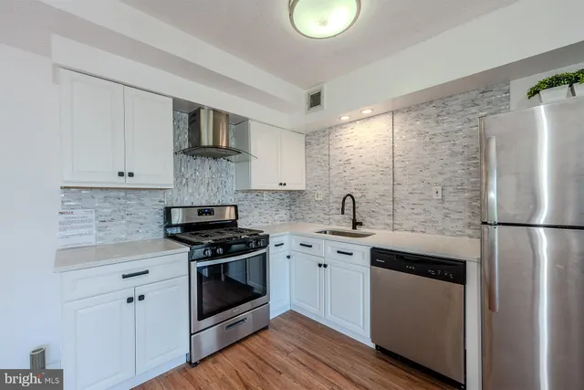 a kitchen with stainless steel appliances granite countertop a stove a refrigerator and a sink