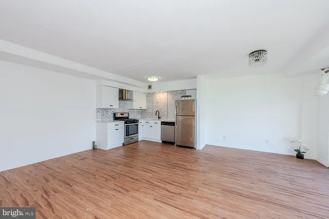 a view of a kitchen with wooden floor and a window