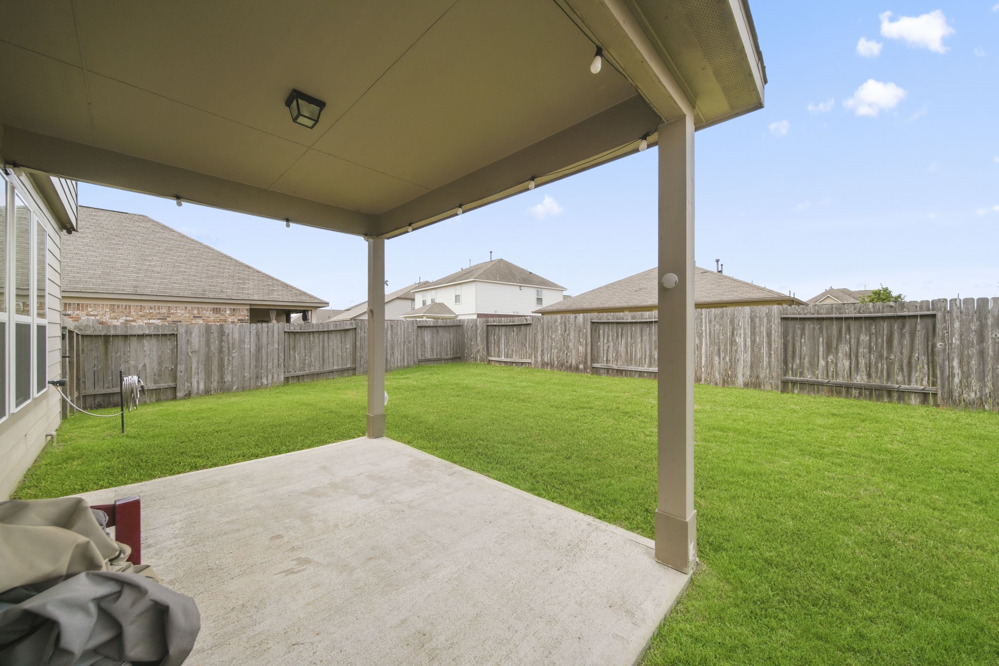 3010 Coachmaker Trail Rosenberg, TX 77471 - Photo 20 of 26 Enjoy the outdoors under a spacious covered patio, complemented by wood fencing that enhances privacy.