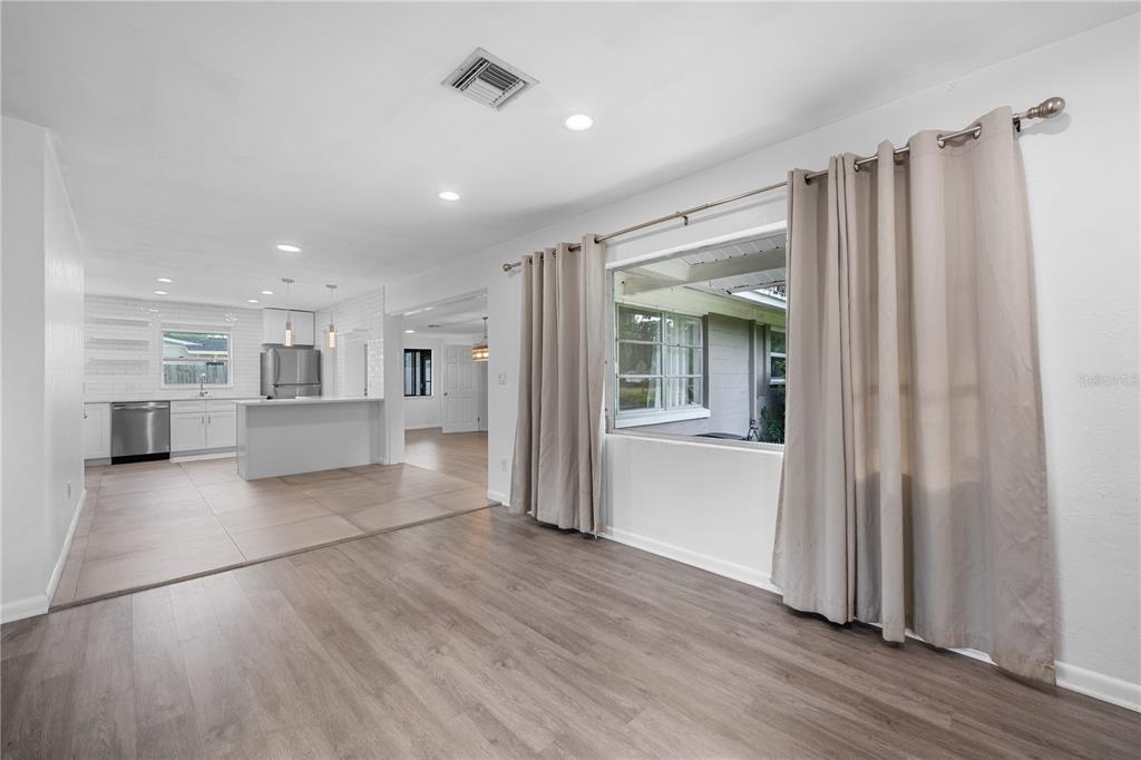 601 Oranole Road Altamonte Springs, FL 32701 - Photo 20 of 36 an empty room with wooden floor and a kitchen