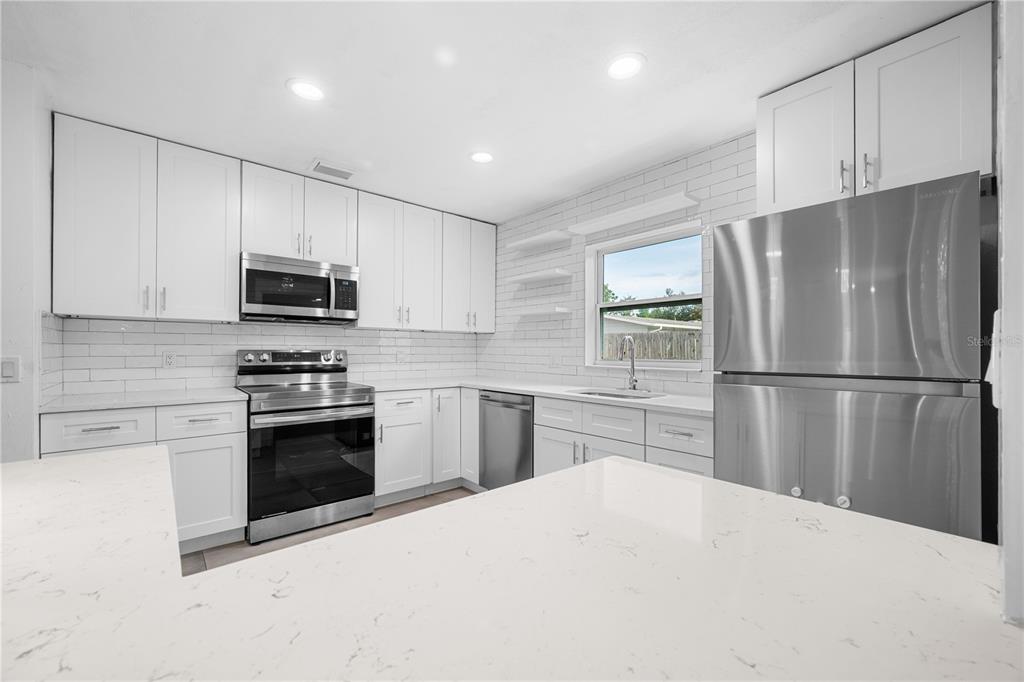 601 Oranole Road Altamonte Springs, FL 32701 - Photo 10 of 36 a kitchen with granite countertop a refrigerator stove and microwave