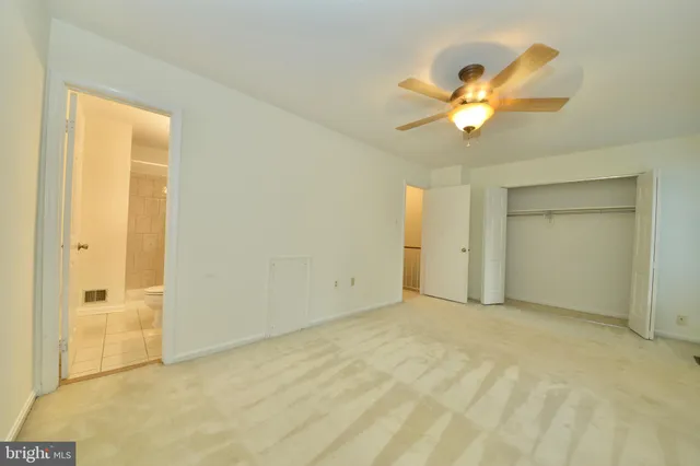 an empty room with a ceiling fan and a window