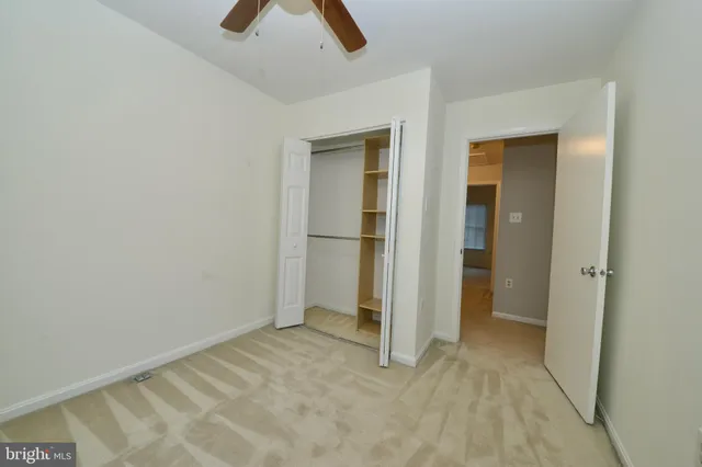 an empty room with closet and windows