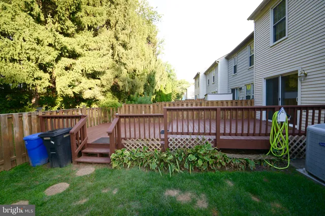 a view of a backyard with wooden fence and a bench
